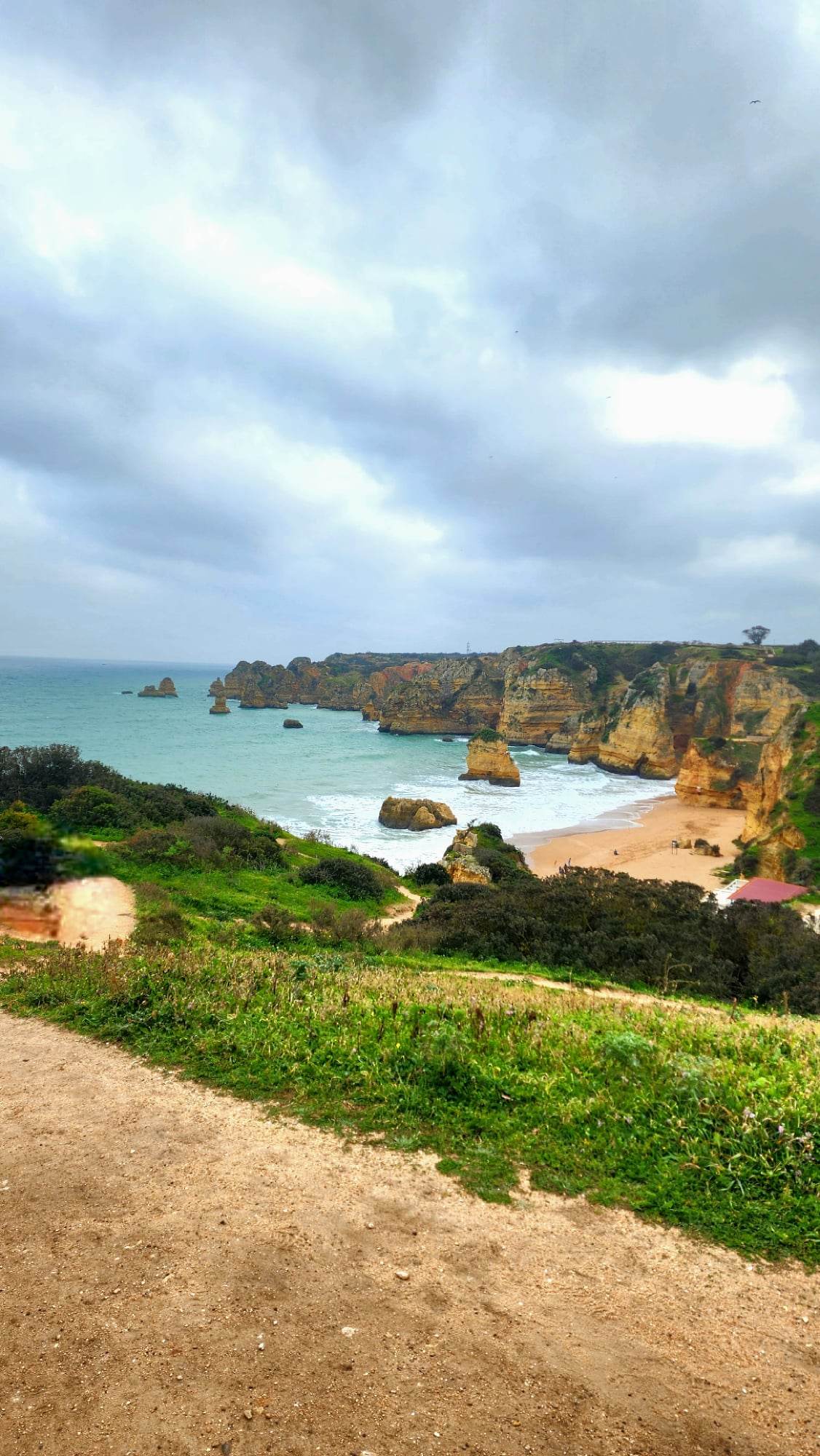 A view of a stunning beach with large cliffs and turquoise water