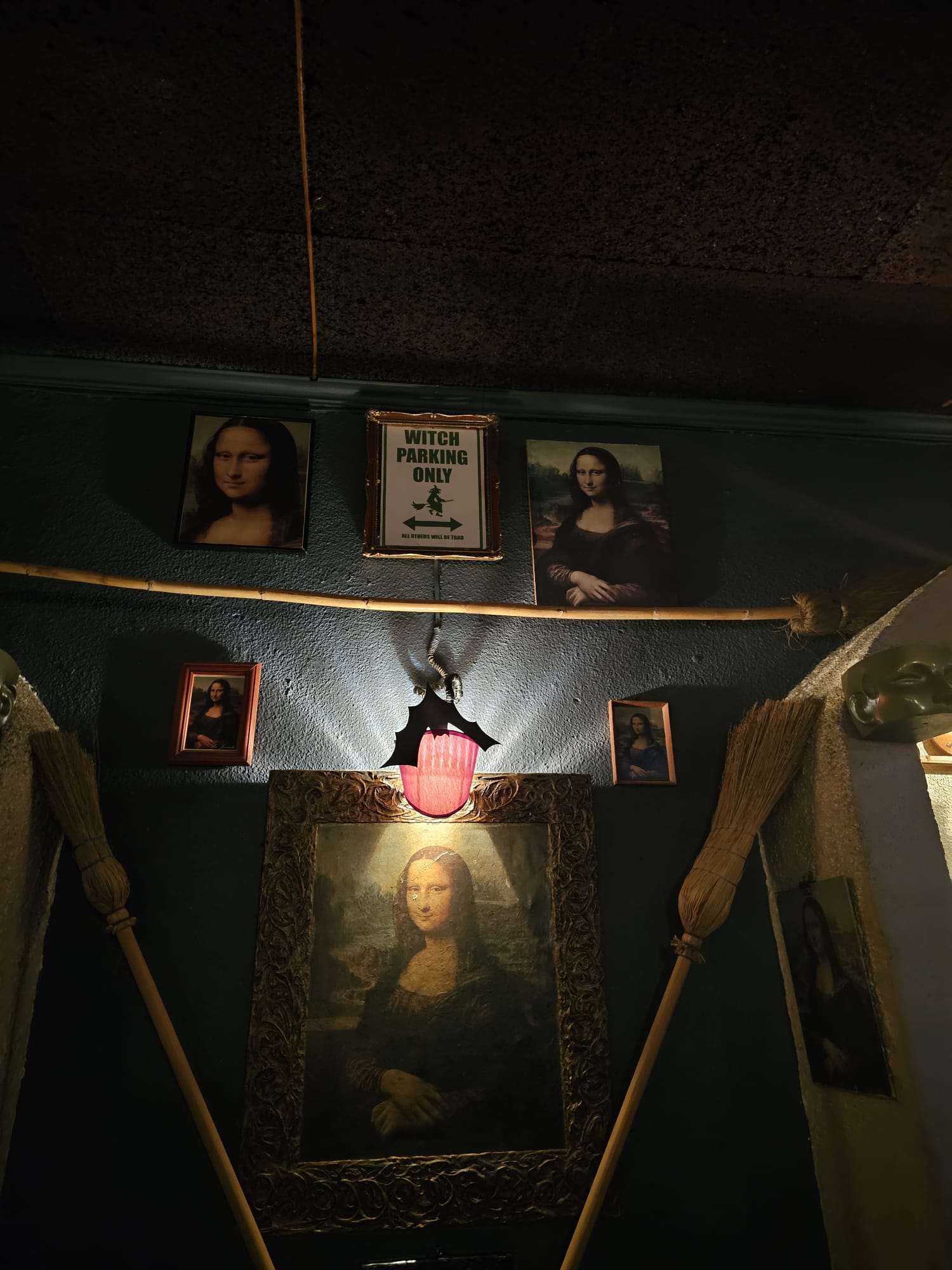 A dimly lit wall with multiple portraits of the Mona Lisa