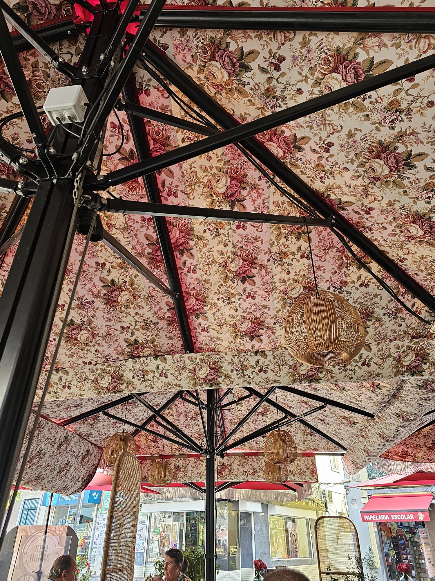 A floral tapestry umbrella and a hanging light fixture