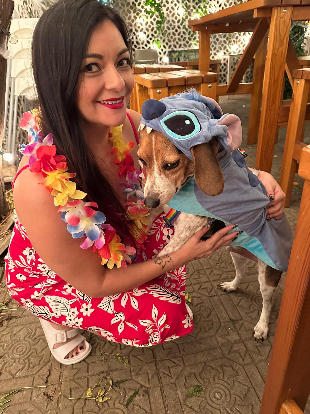 Woman dressed as Lilo holding her beagle dog Bodhi dressed in a Stitch costume for Halloween in Portugal