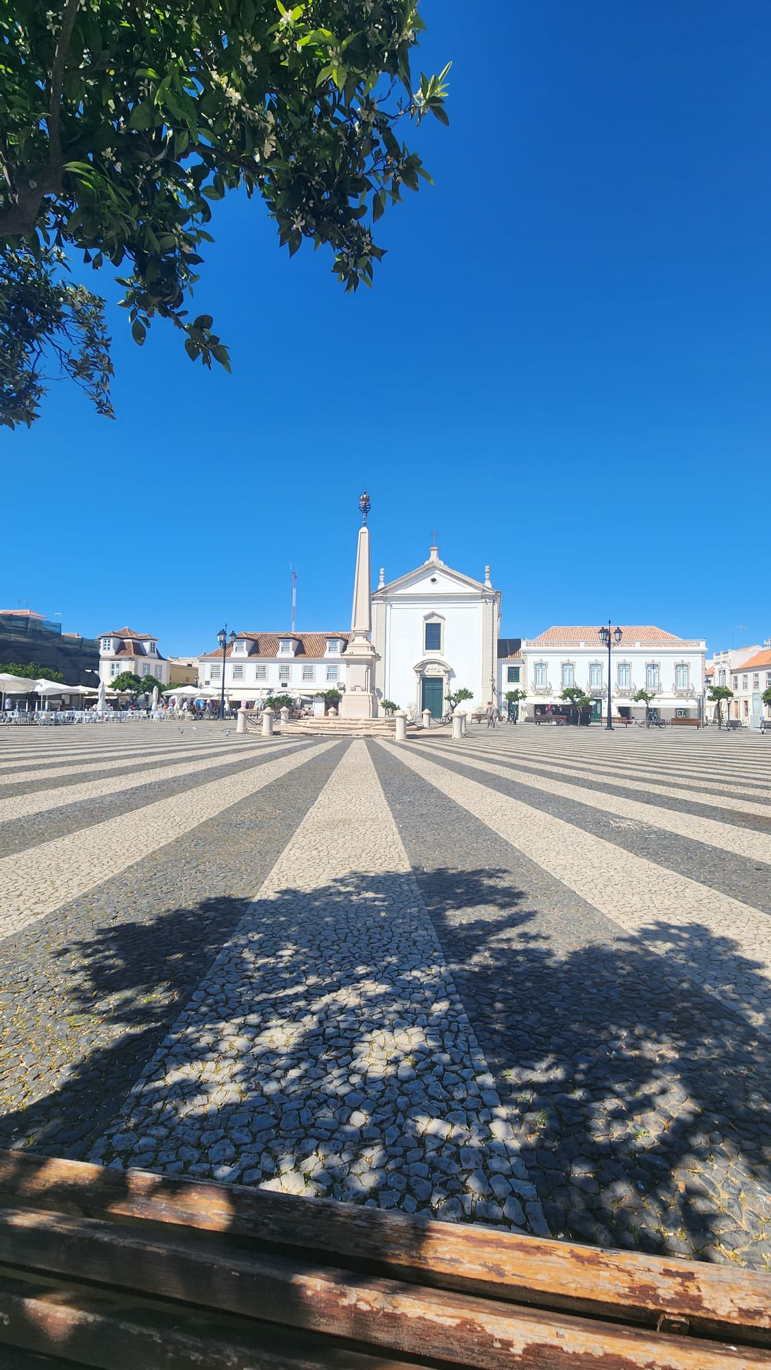 Sunny main square of Vila Real de Santo António with obelisk and whitewashed church in the Algarve Portugal