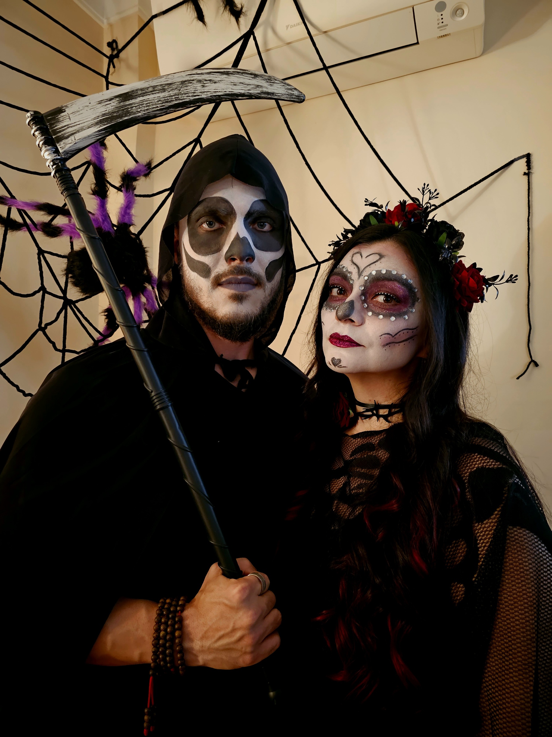 Couple dressed as La Catrina and the Grim Reaper with elaborate face paint at a Halloween party in Tavira Portugal