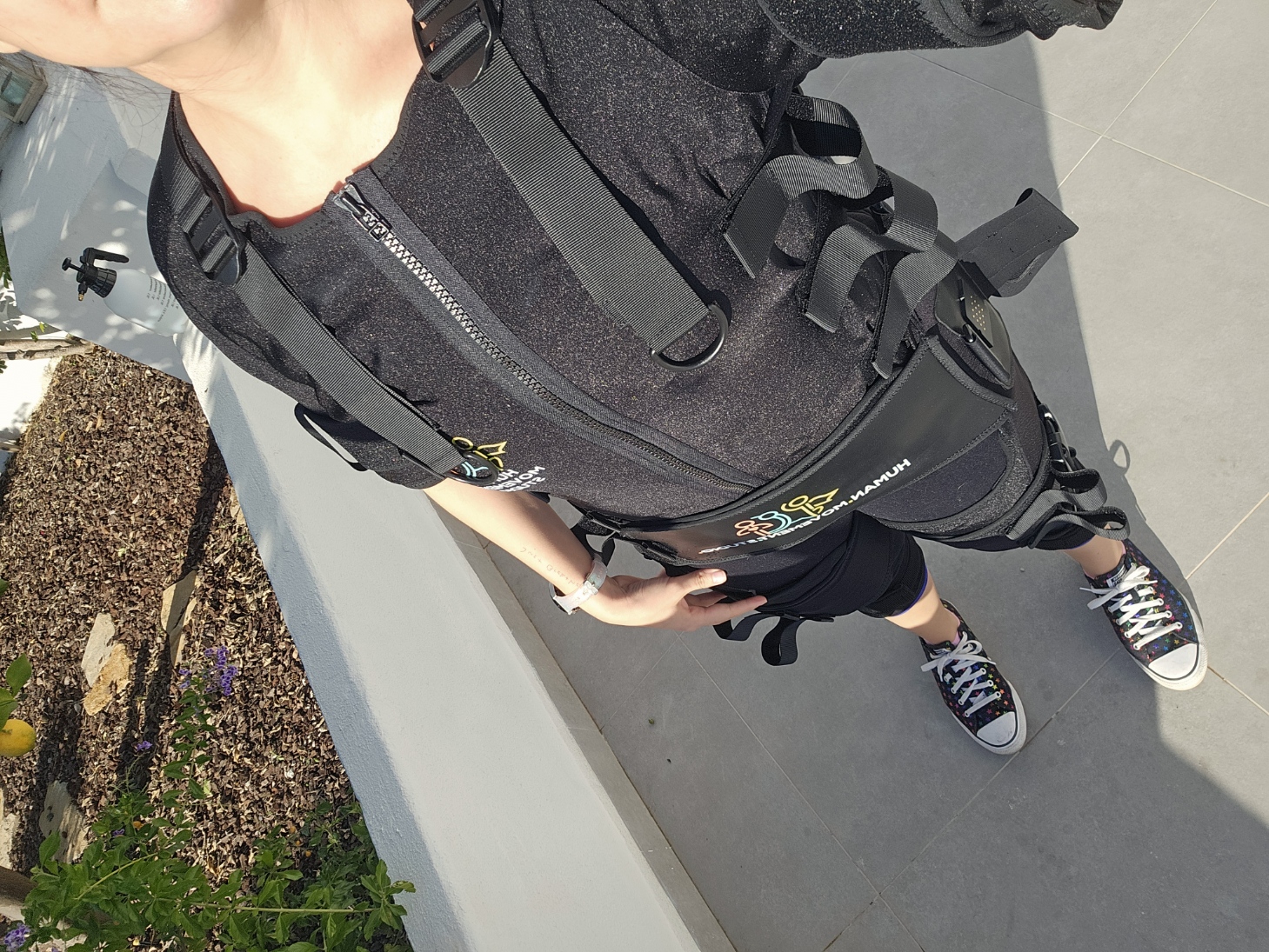Woman wearing a full body black EMS training suit with electrode attachments at Human Movement Studio in Portugal