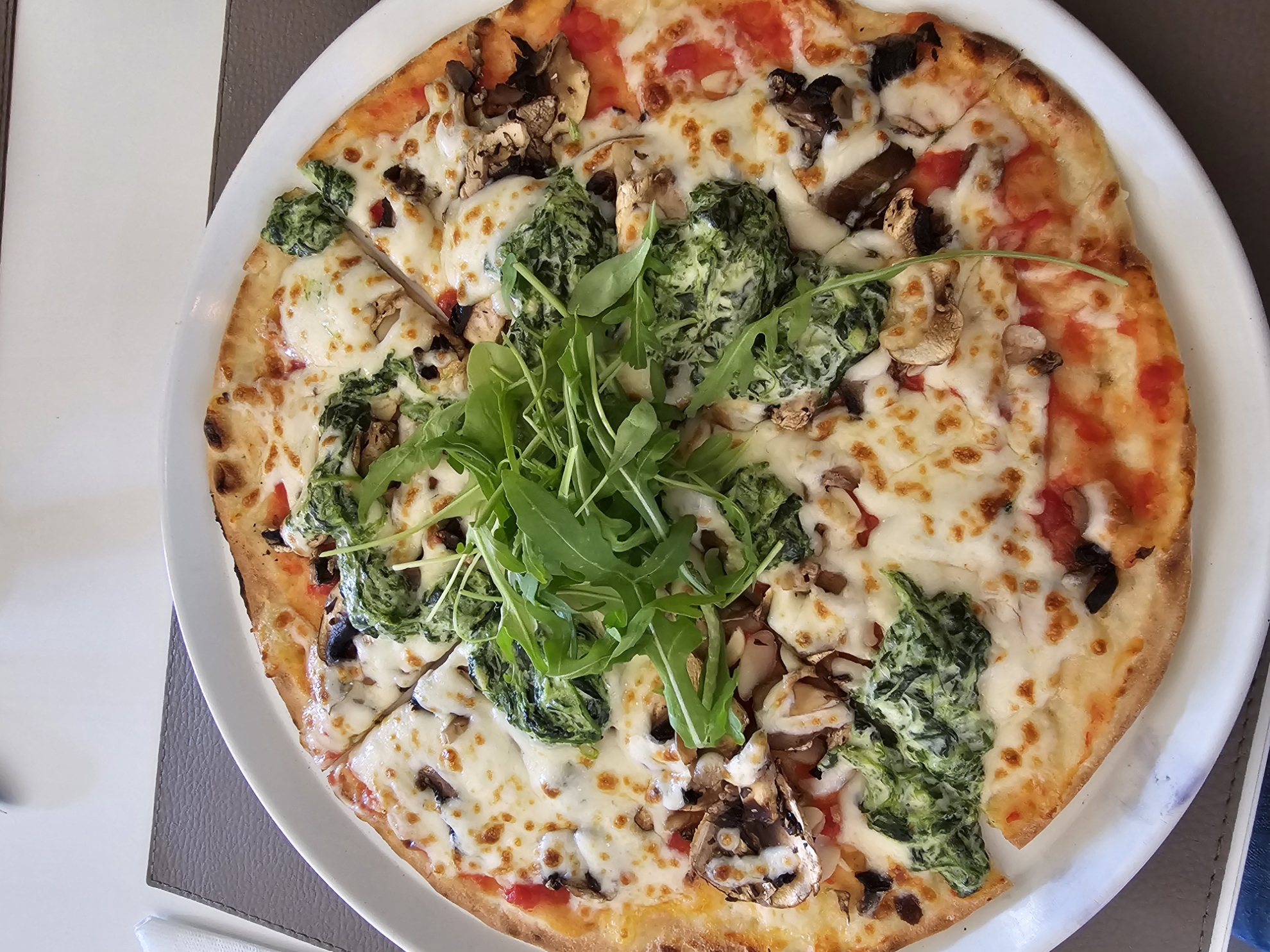 Montalcino gluten free pizza topped with spinach, mushrooms and arugula at Pizza na Pedra in Olhão Portugal