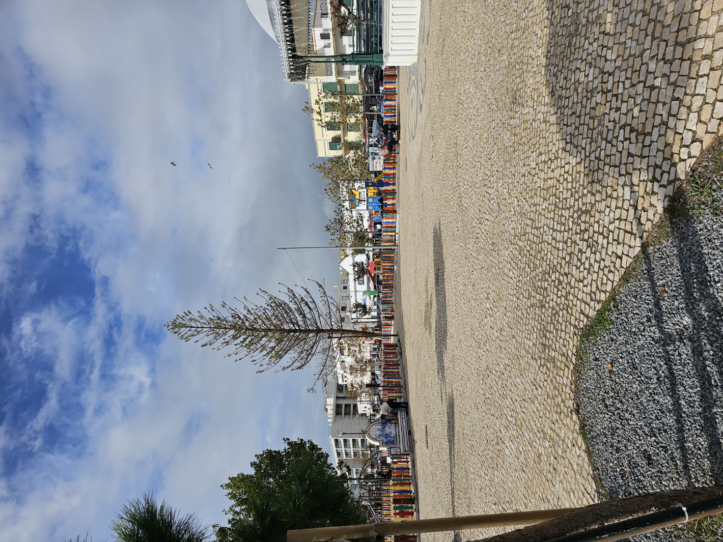 Open cobblestone waterfront area with Christmas tree near the kids play zone in Olhão Portugal