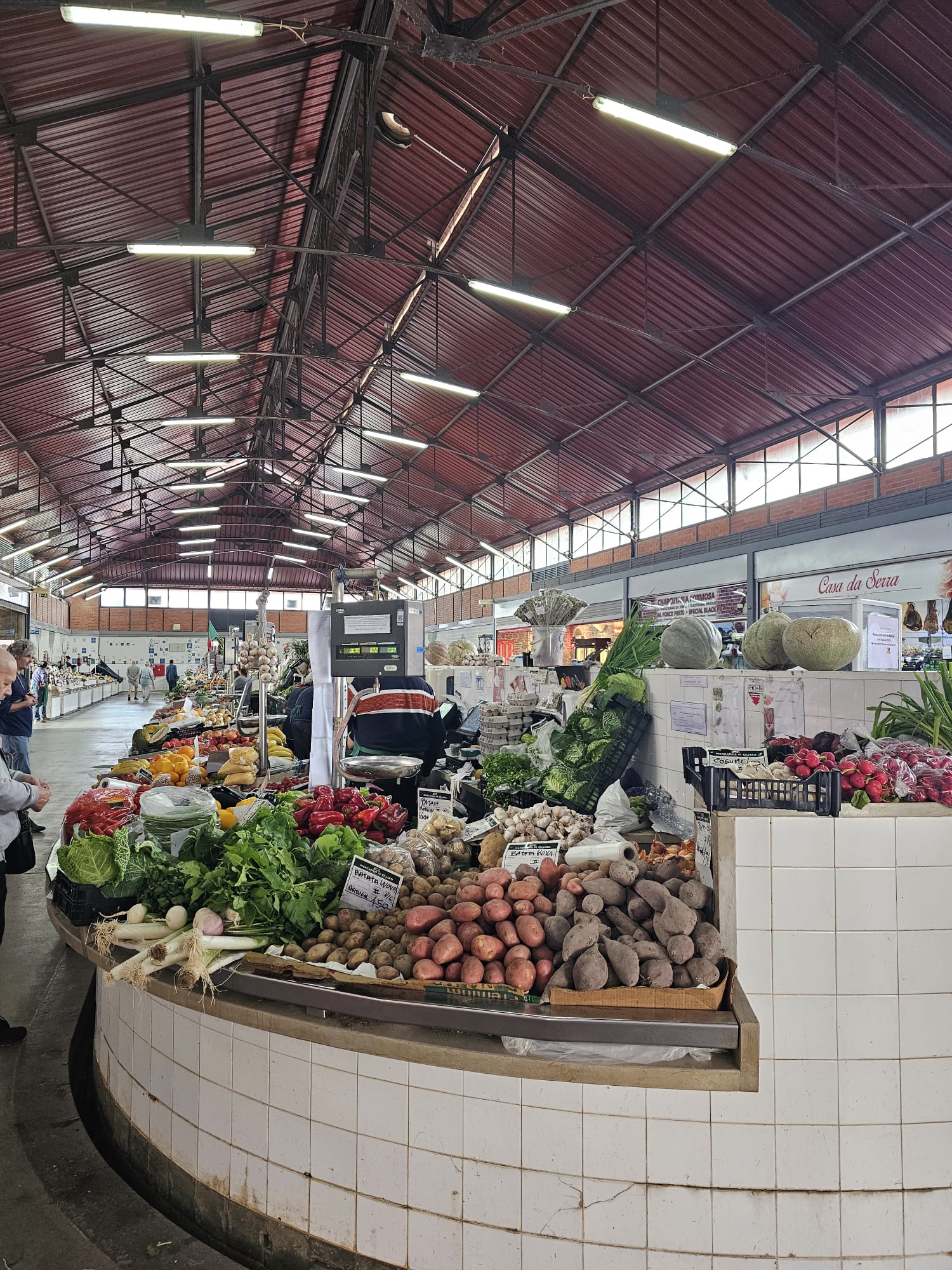 Inside one of the Olhão market halls showing rows of fresh produce and vegetables