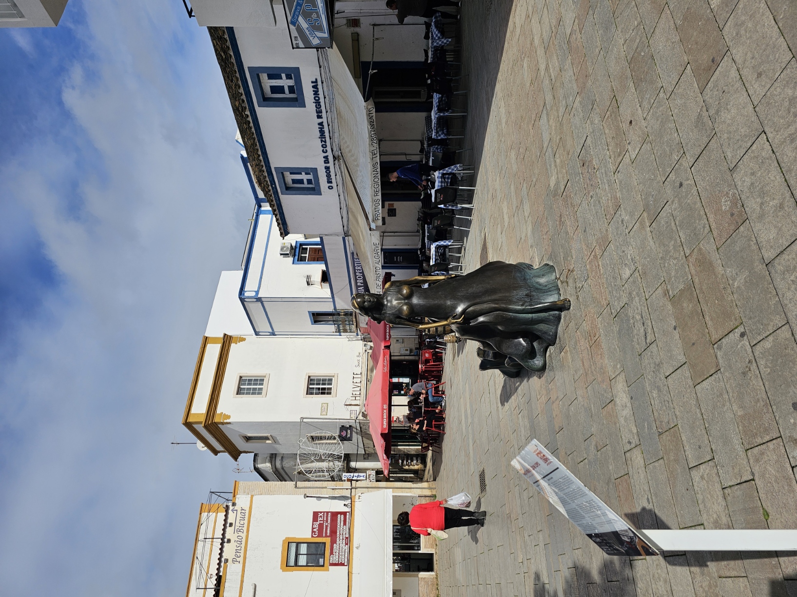 Bronze statue of the Legend of Floripes in the main square of Olhão Portugal surrounded by traditional whitewashed buildings