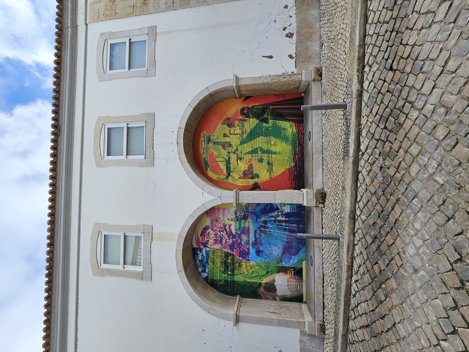 Vibrant colorful street art murals painted inside the arched doorways of a building in Olhão Portugal