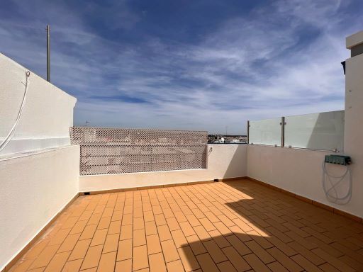 Empty rooftop terrace with terracotta tile flooring and open sky views in Tavira Portugal