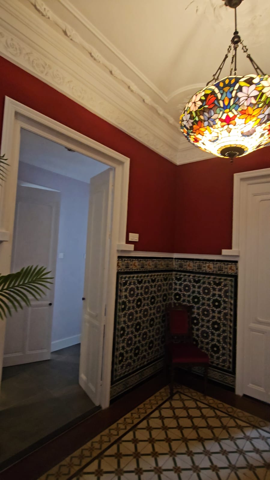 Ornate entryway of Casa Verde apartment with traditional Portuguese azulejo tiles and Tiffany chandelier
