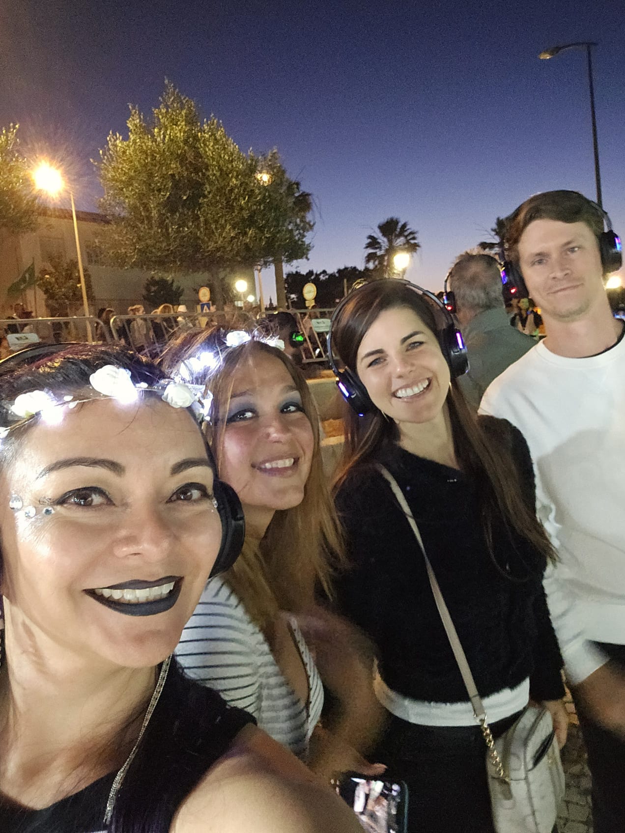 Group of friends wearing silent disco headphones at the Carvoeiro Black and White Night festival in Portugal