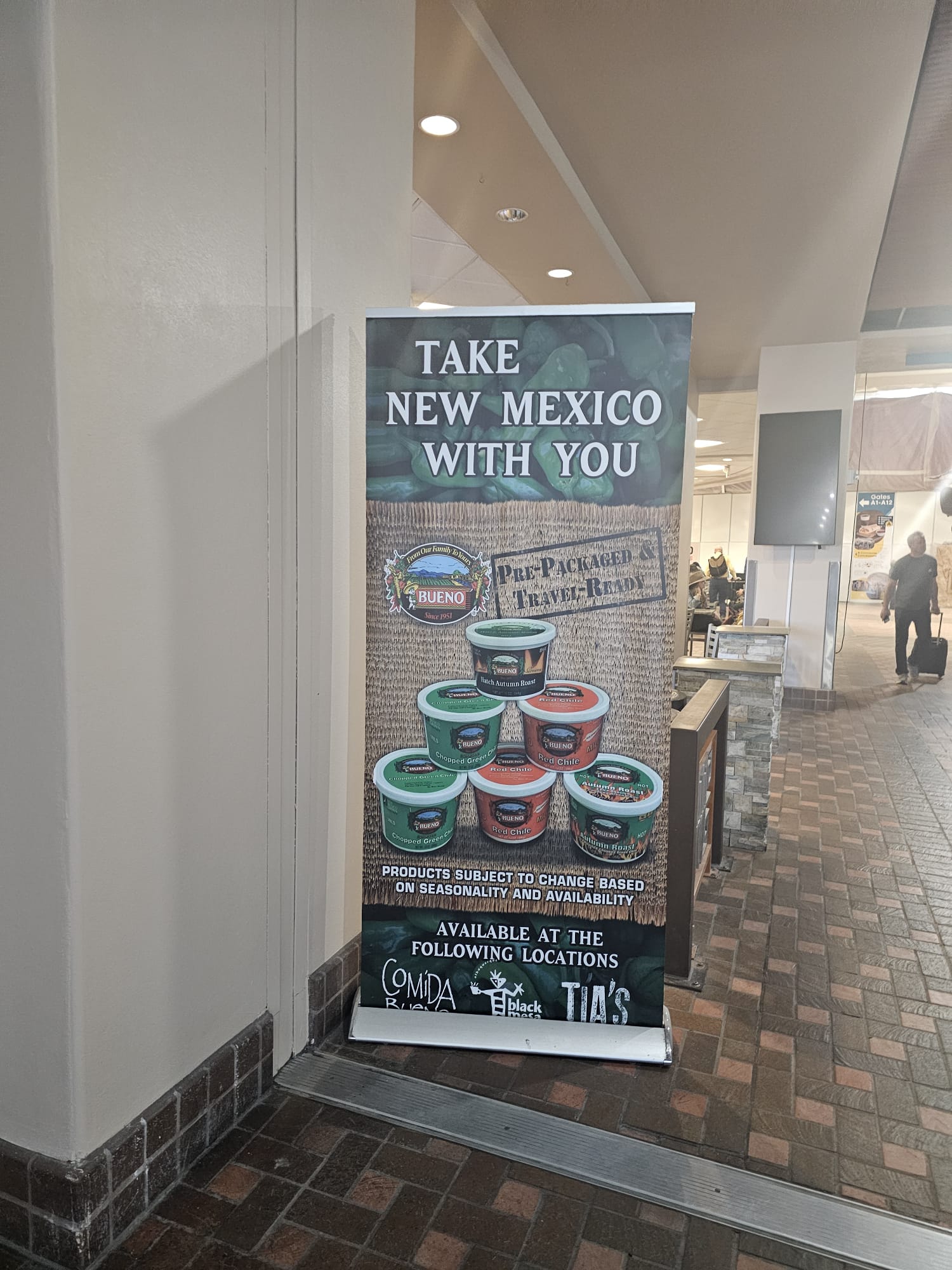 New Mexico green chile and salsa products display at Albuquerque airport with a Take New Mexico With You sign