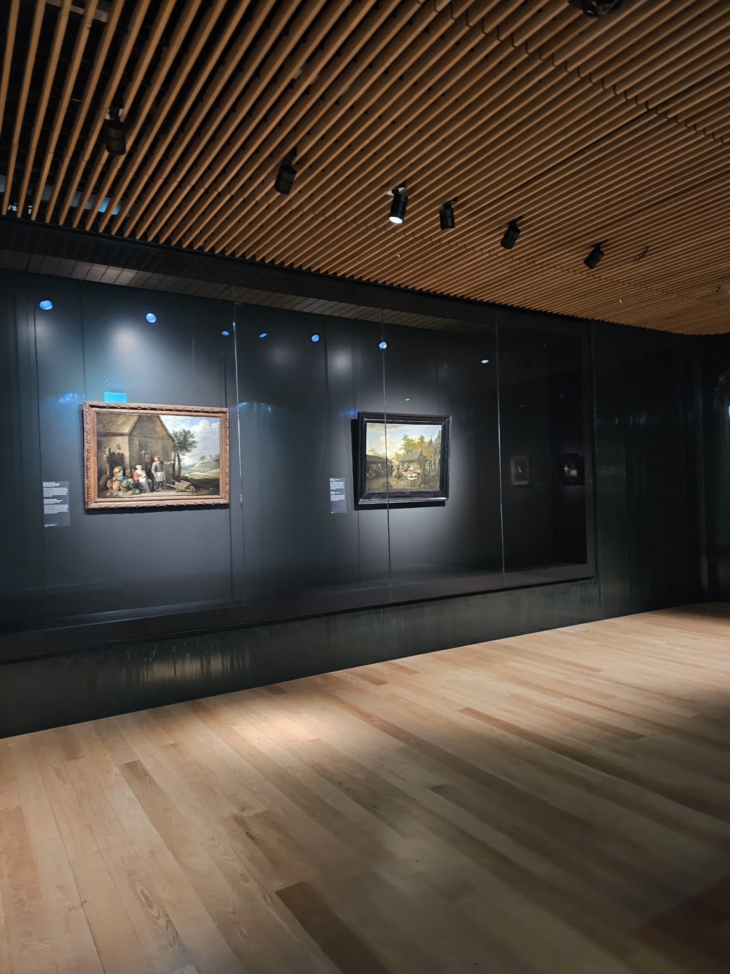 Dutch Golden Age paintings displayed in a dimly lit gallery inside the Rijksmuseum satellite exhibit at Amsterdam Schiphol Airport