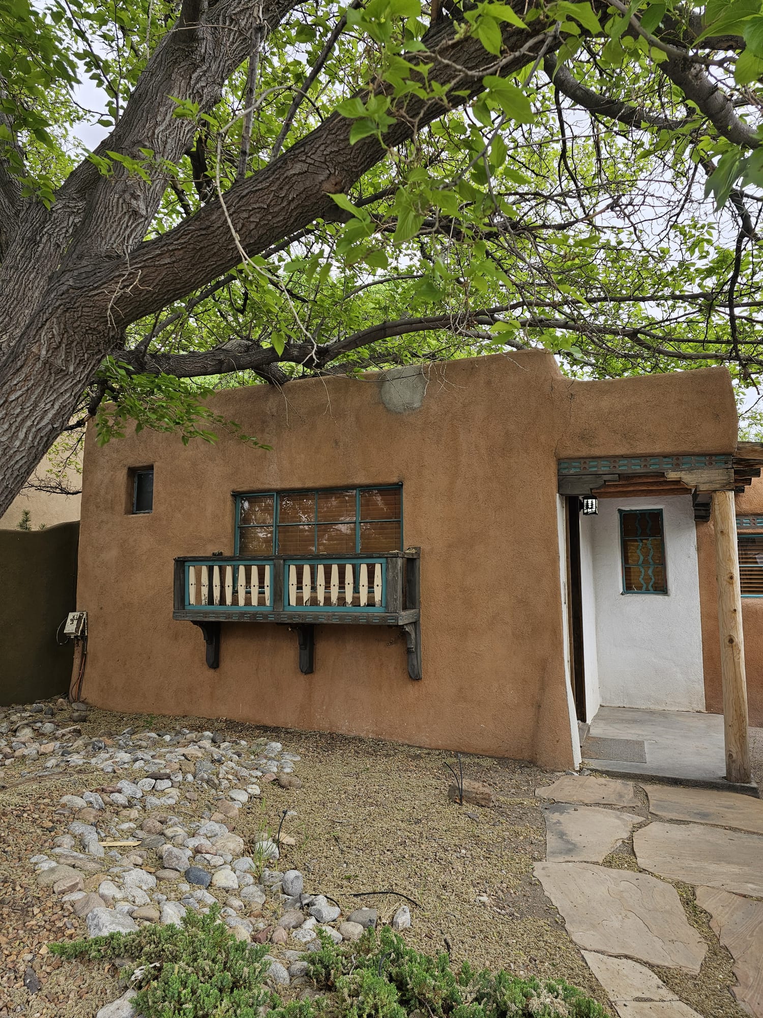 Exterior of a traditional adobe casita guest room with wooden window accents at Casas de Suenos bed and breakfast in Albuquerque, New Mexico