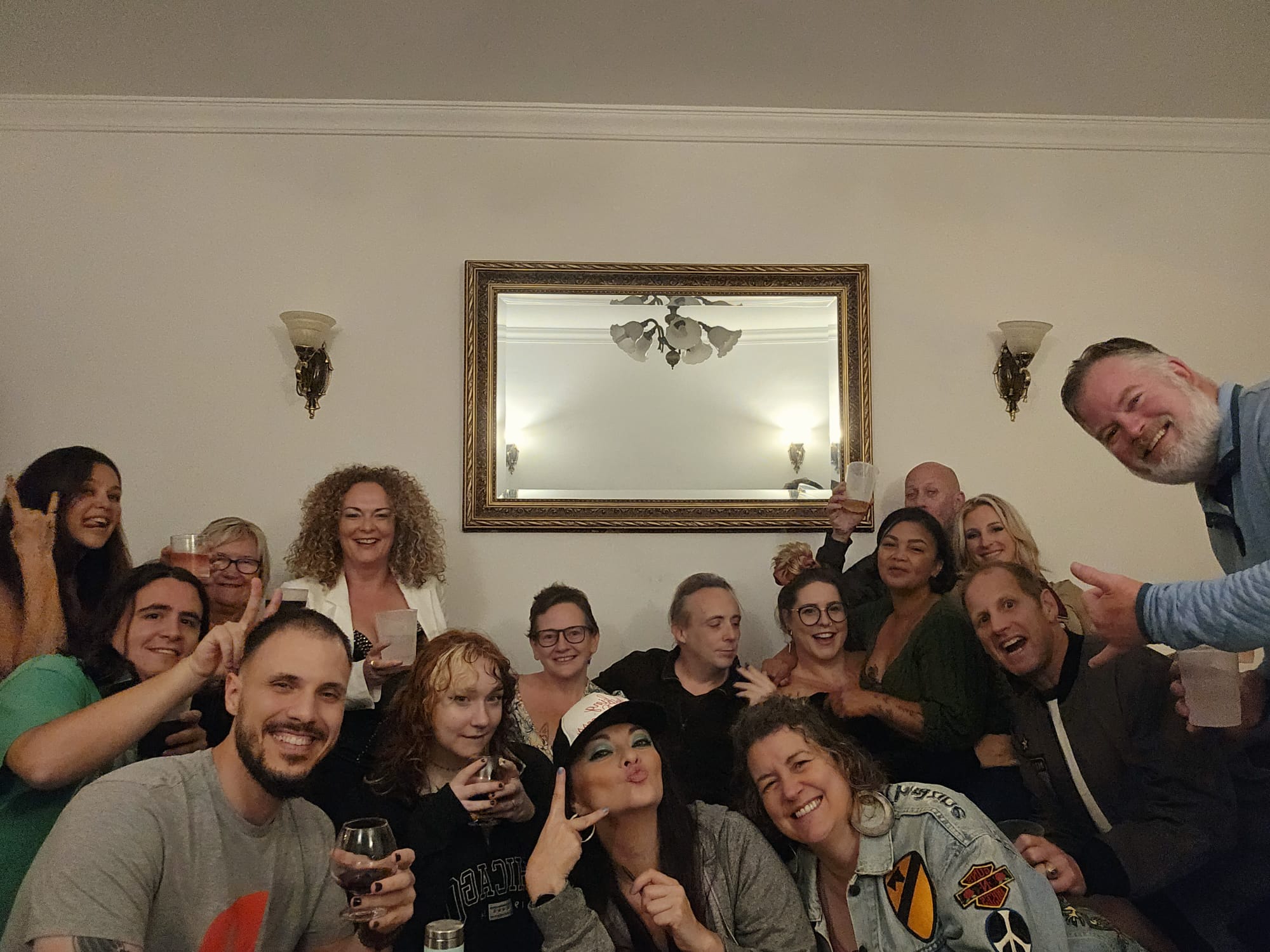 Large group of expat and Portuguese friends crowded together smiling and making silly faces at a birthday party in Portugal
