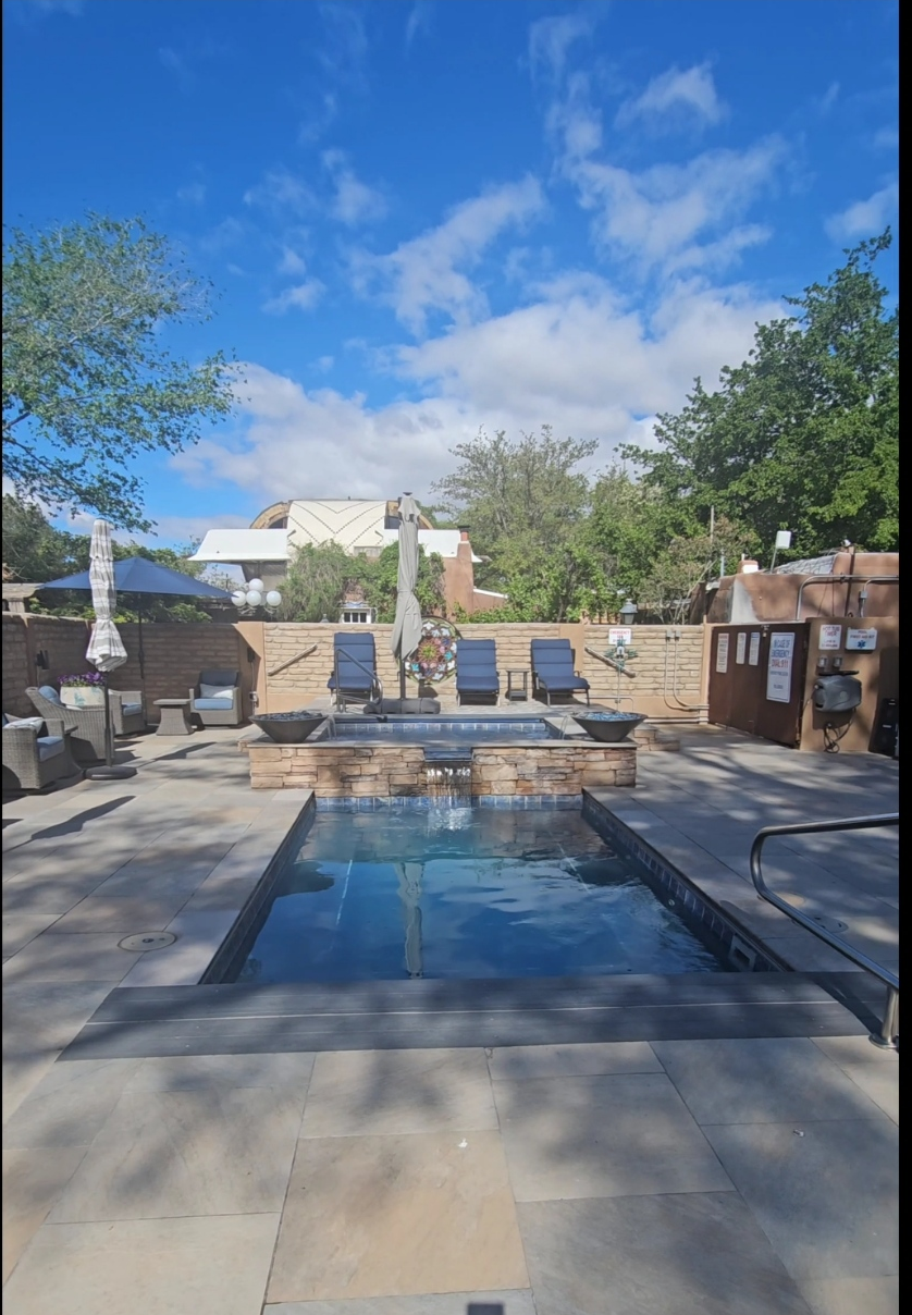Outdoor hot tub and pool area with lounge chairs at Casas de Suenos bed and breakfast in Albuquerque, New Mexico