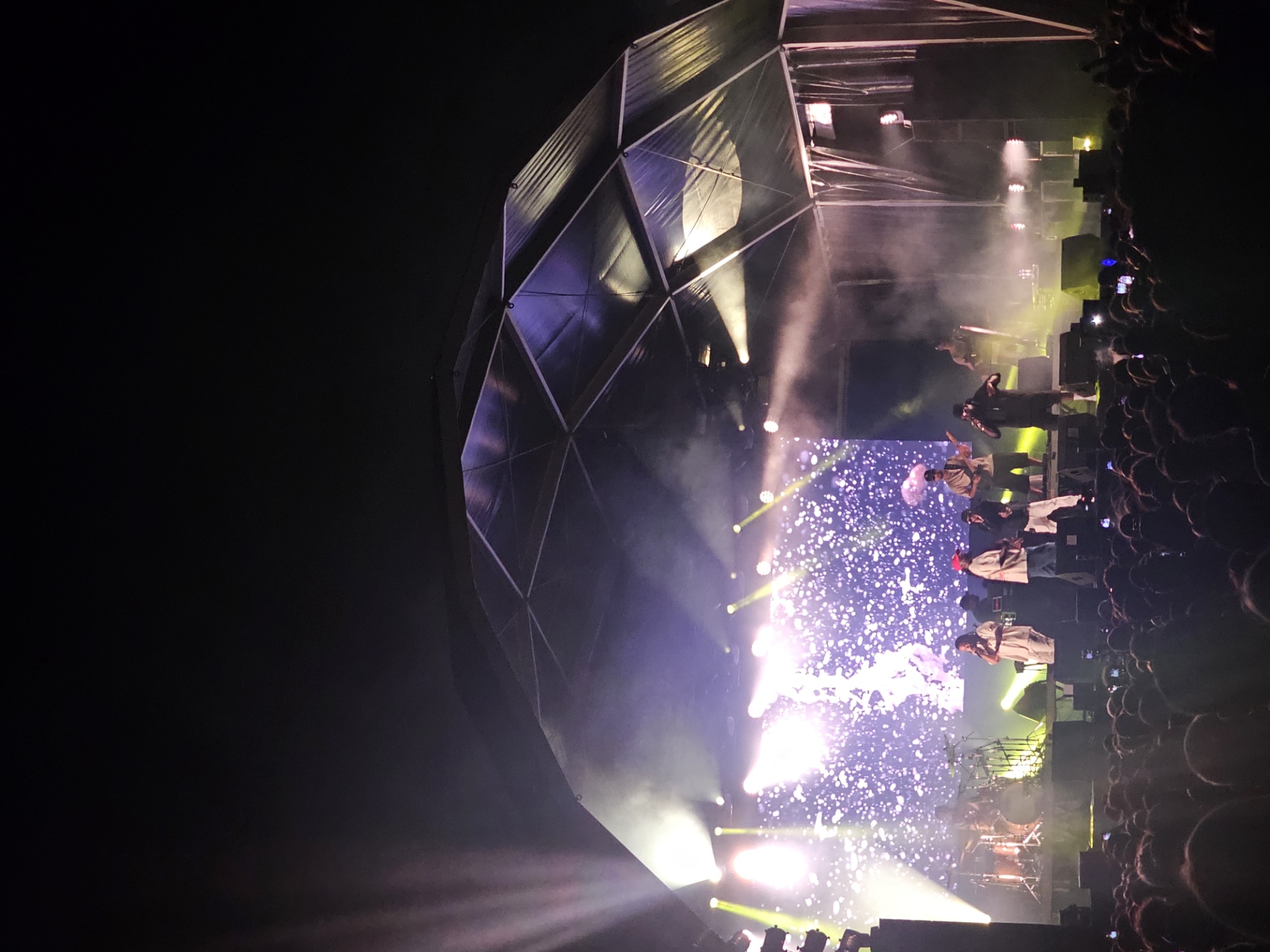 Wet Bed Gang performing on stage under a geodesic dome structure at Festa da Juventude in Tavira, Portugal, with purple and white stage lights illuminating the crowd