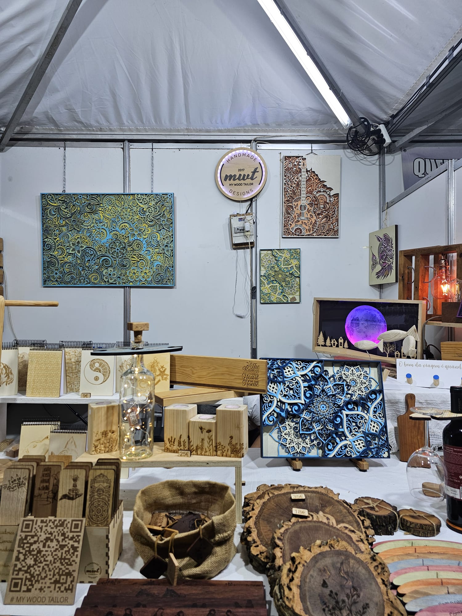 Colorful wooden art pieces and handcrafted items displayed inside a vendor booth at the Mediterranean Diet Fair in Portugal