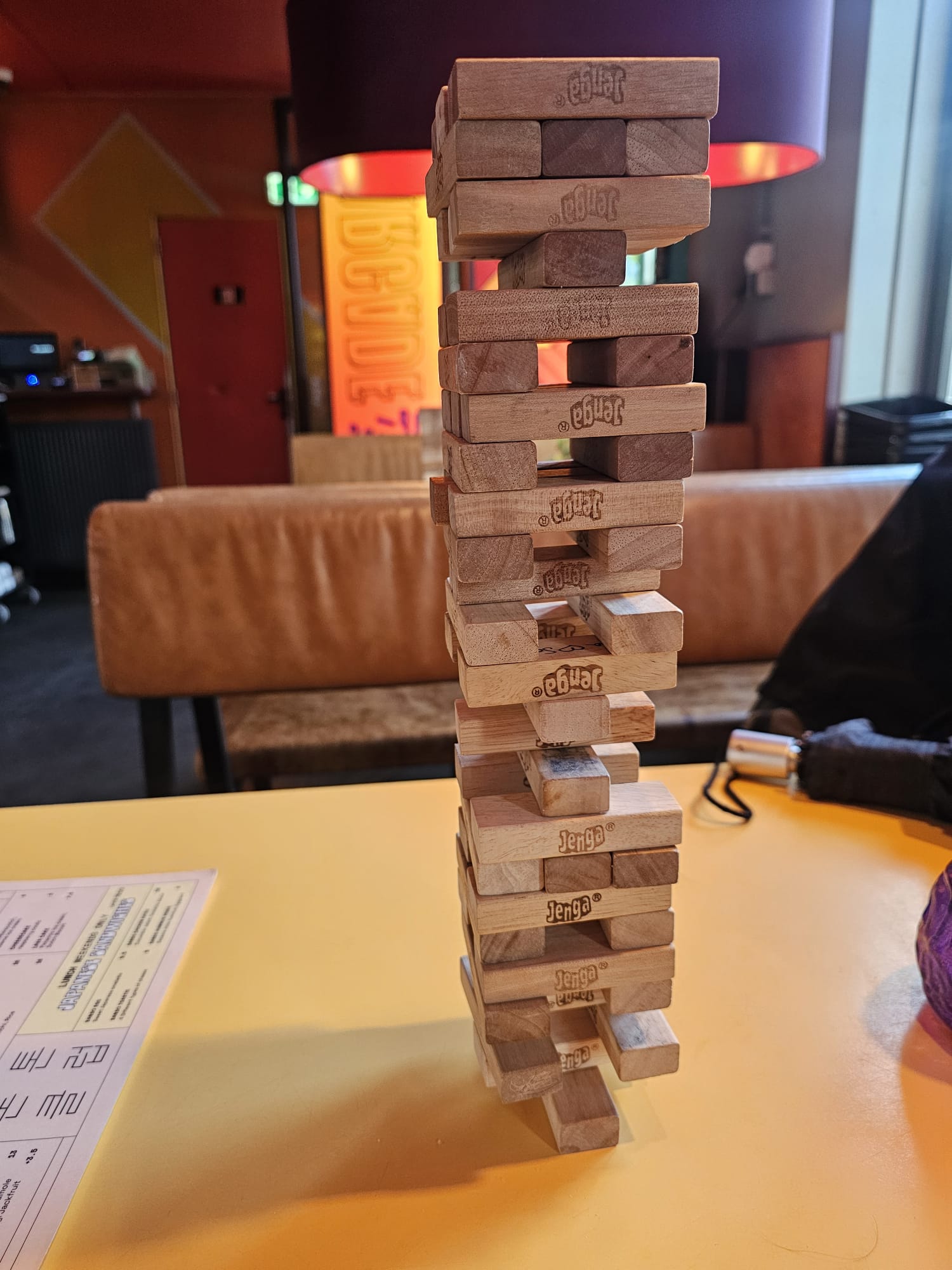 Tall and precarious Jenga tower mid-game on a table at a bar in Amsterdam