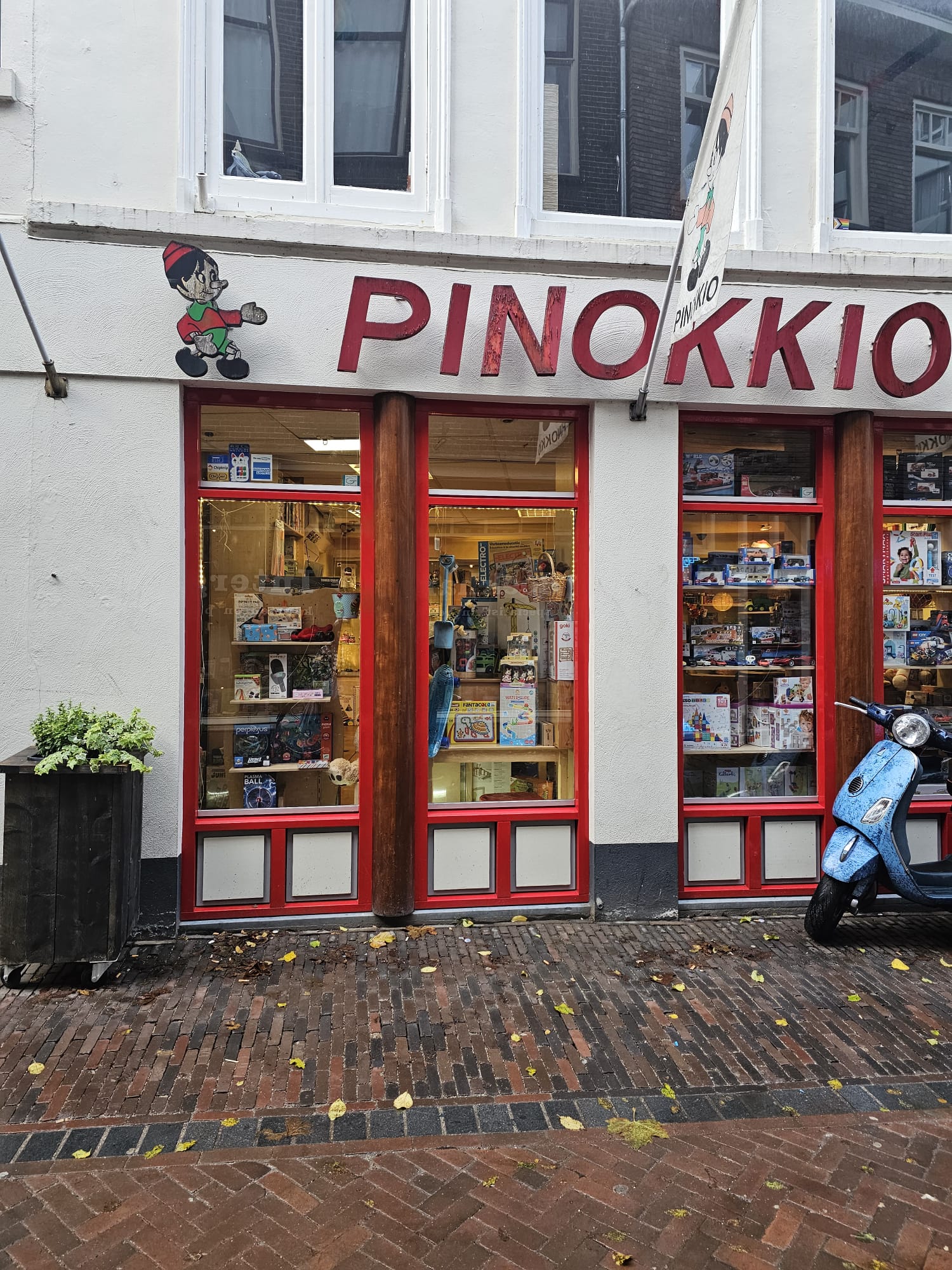 Exterior of Pinokkio toy shop with a Pinocchio character painted above the red-trimmed windows in Utrecht, Netherlands