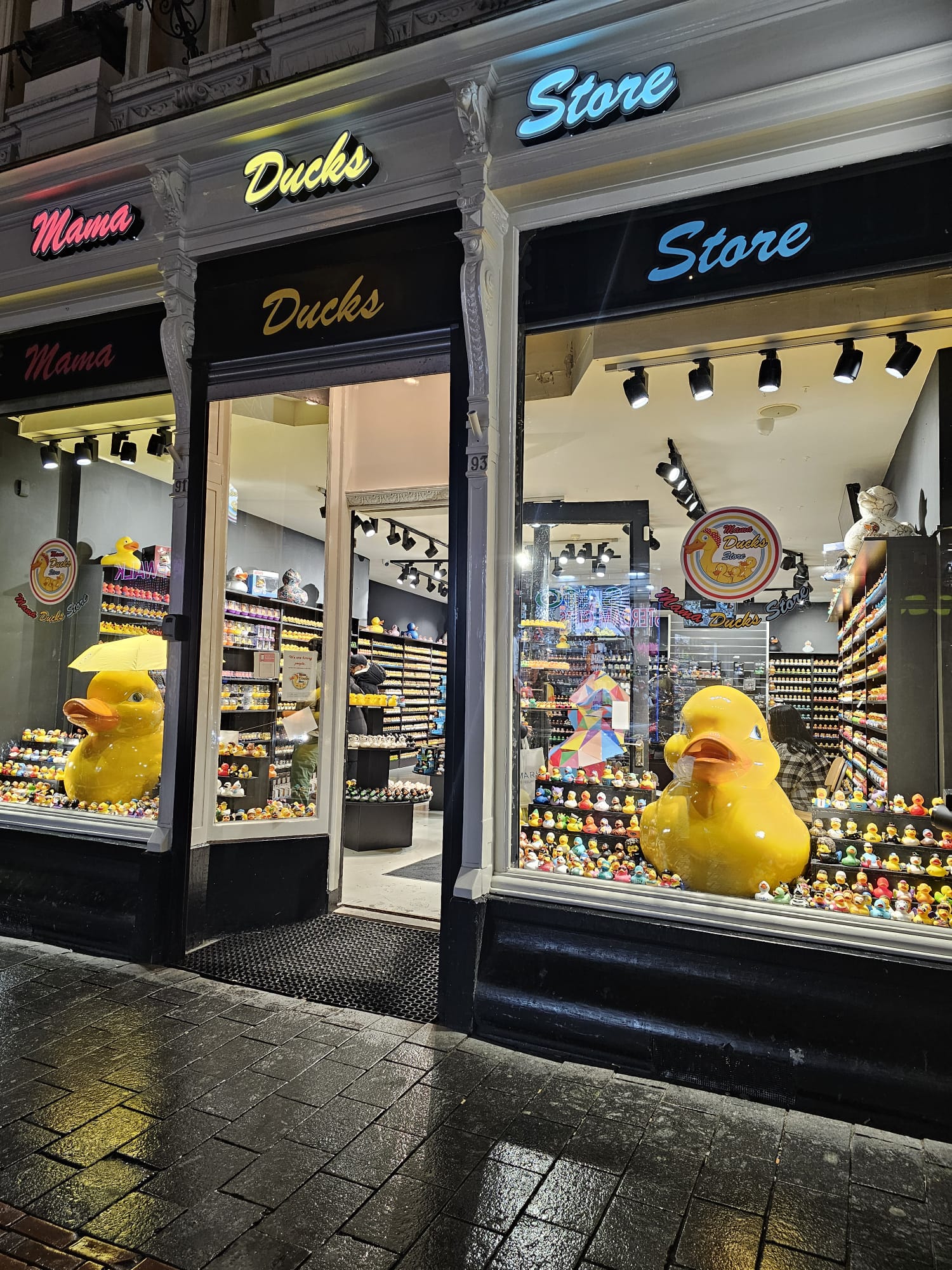 Storefront of the Mama Ducks rubber duck souvenir shop near the canals in Amsterdam, with giant yellow rubber ducks in the window display