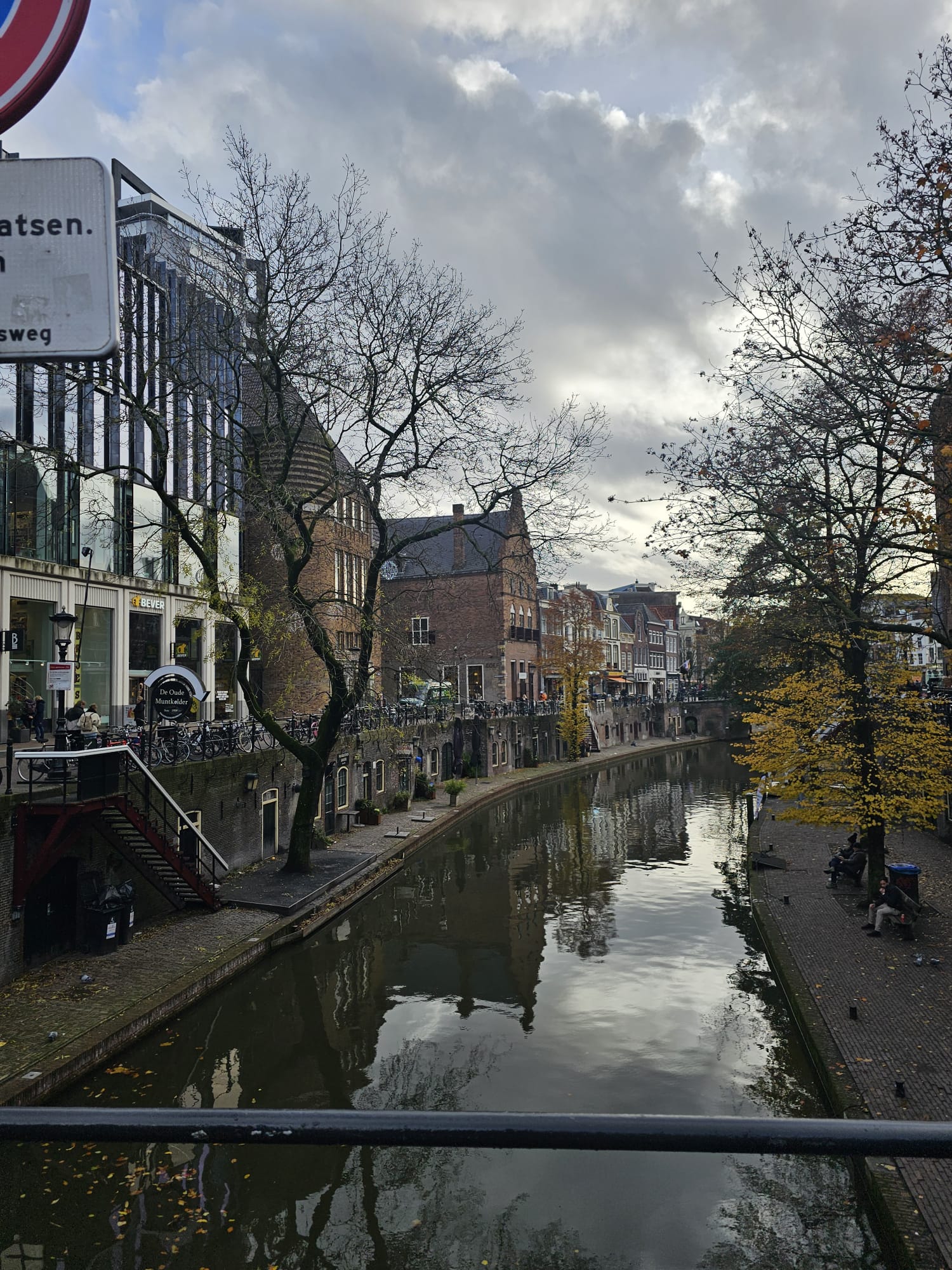 Tree-lined canal with historic brick buildings reflecting in the water in the city center of Utrecht, Netherlands