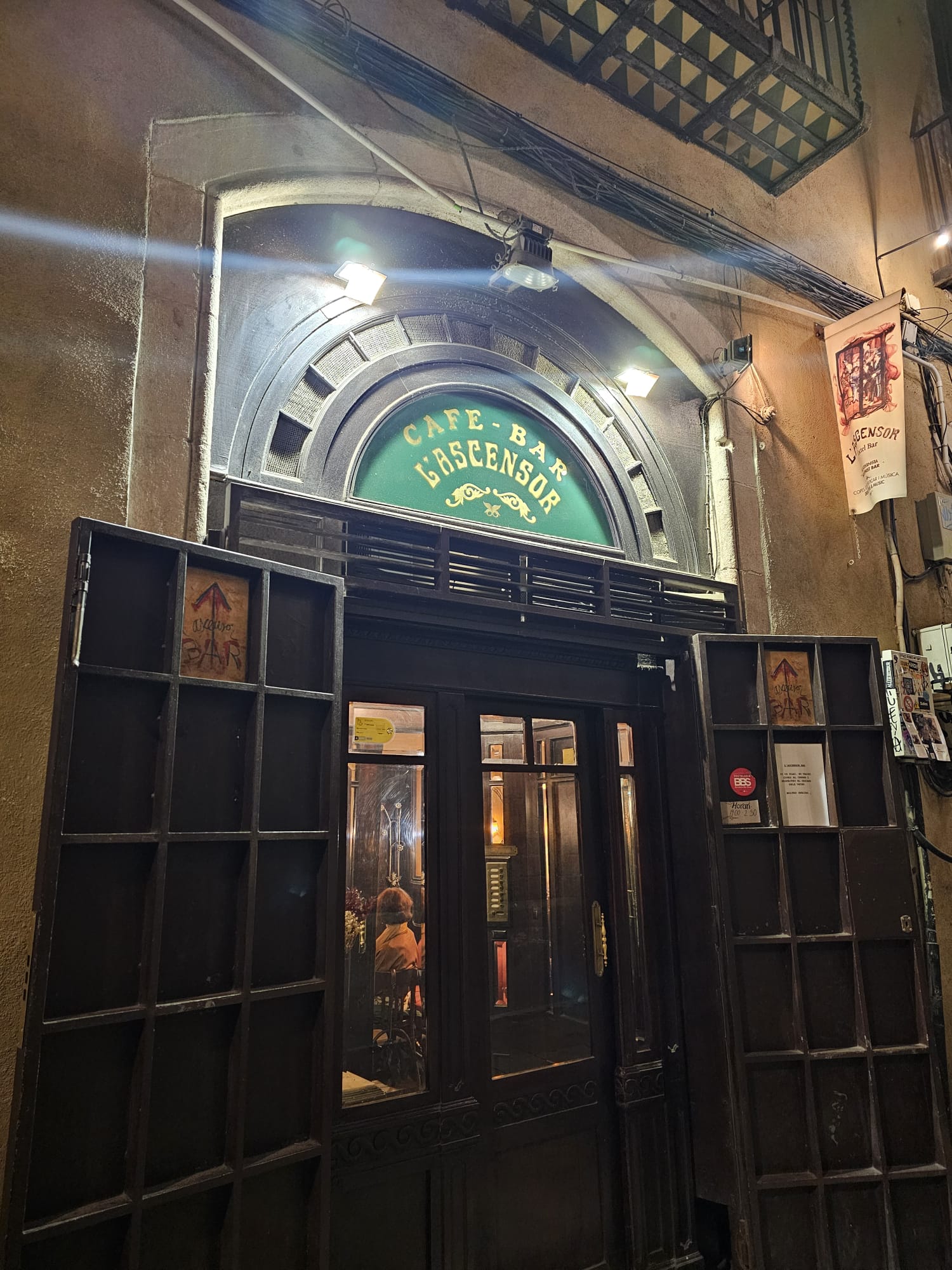 Vintage wooden entrance of Cafe Bar l'ascensor with arched signage in Barcelona's Gothic Quarter