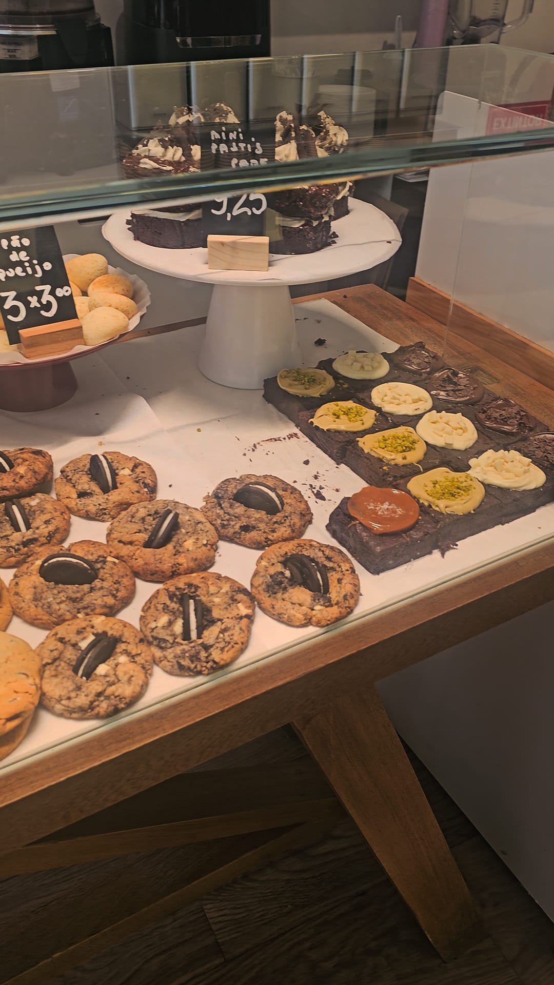 Close-up of gluten-free cookies, chocolate bark, and mini tarts in the pastry display case at Chök the Chocolate Kitchen