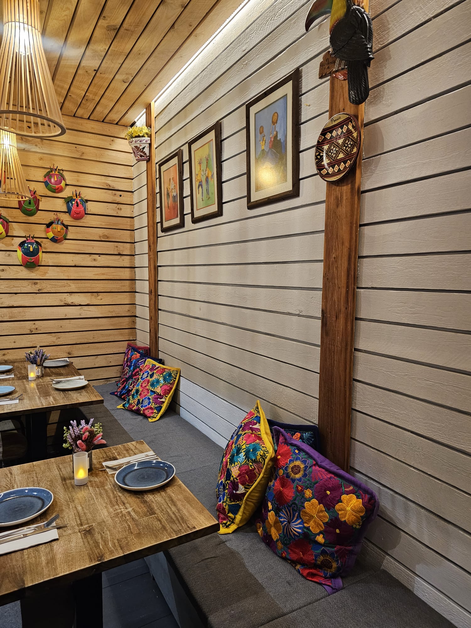 Interior view of Kiltro Restrobar featuring wooden decor, colorful cushions, and set tables.