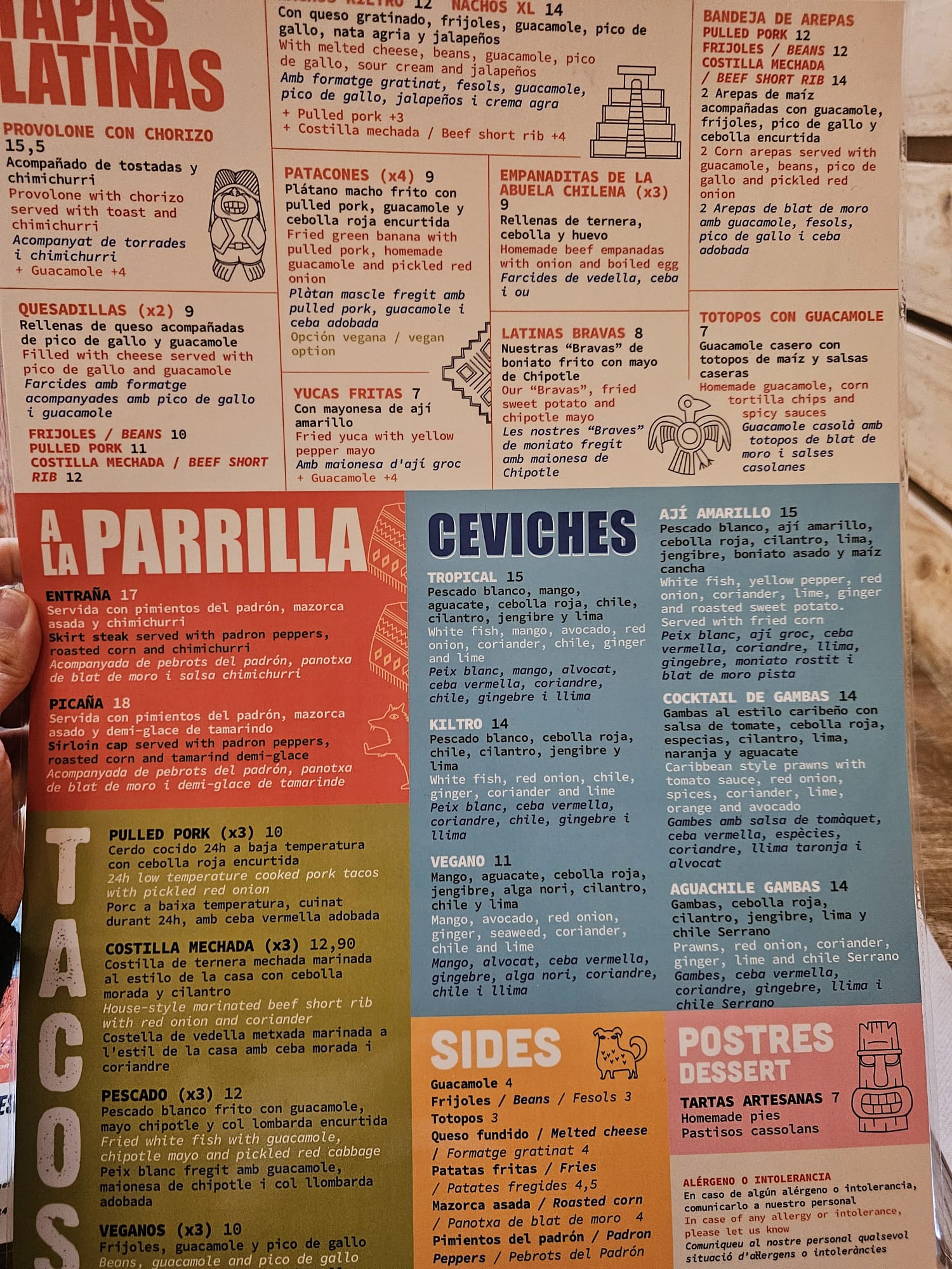 Large illustrated menu board at Kiltro Pisco Restobar showing tapas latinas, parrilla, and ceviches sections