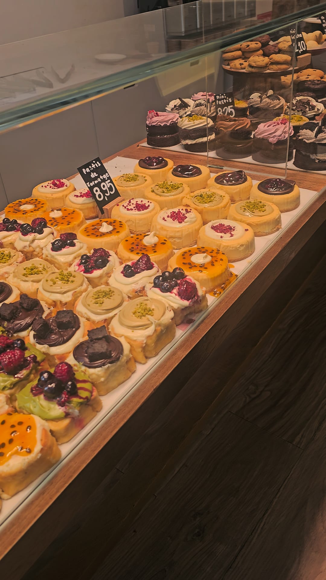Display case of colorful gluten-free cinnamon rolls and mini cheesecakes at Chök the Chocolate Kitchen in Barcelona