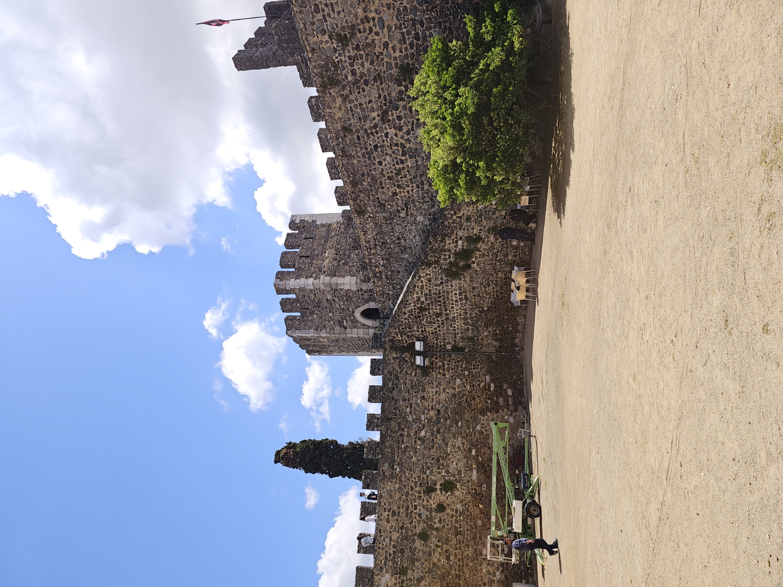 Ancient stone castle with crenellated towers and battlements under a bright blue sky in Beja, Portugal