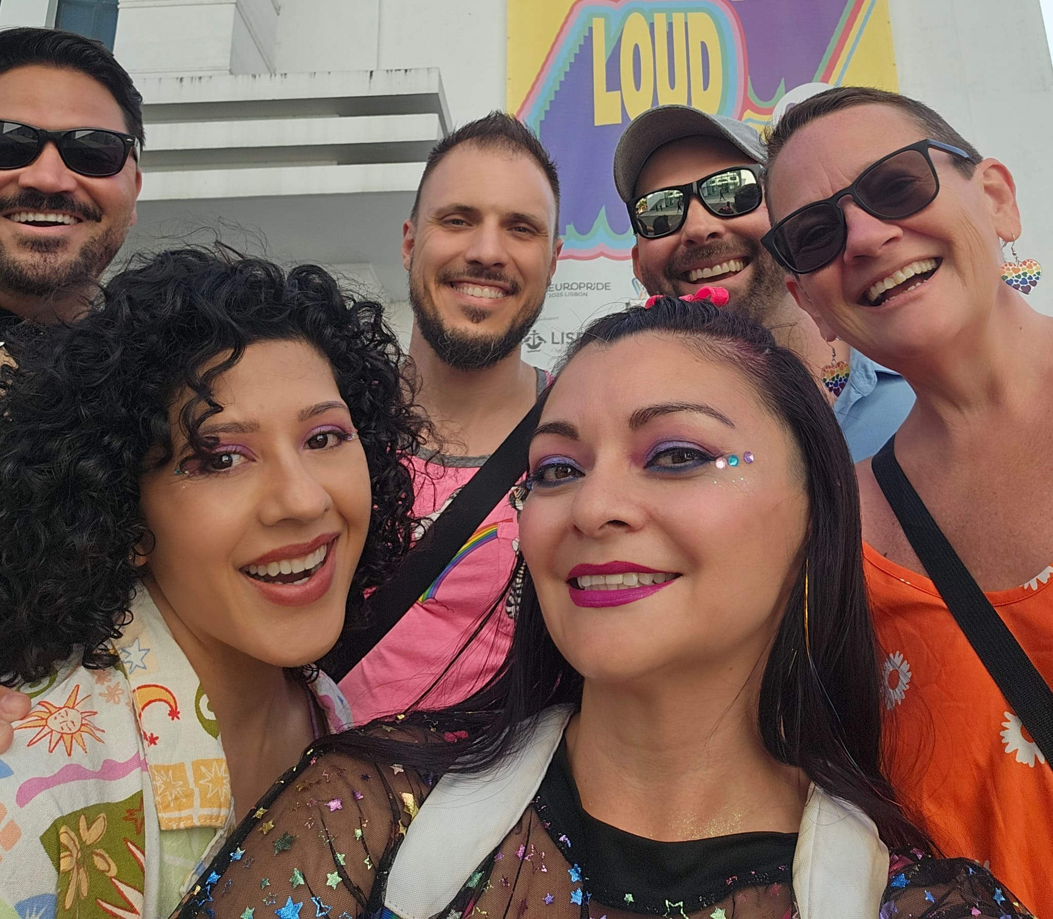 A group of people, smiling, posing for a selfie. 