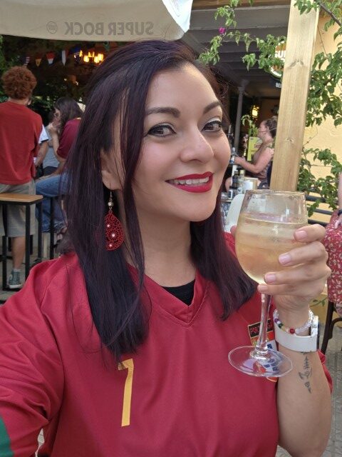 a woman in a Ronaldo jersey holds a glass of wine